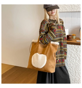 Dettaglio della borsa tote in pelle scamosciata con patch mela in peluche