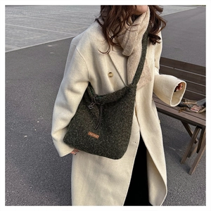 Detail view of a green fuzzy crossbody bag with drawstring and our fave leather patch
