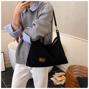 Détail du sac cabas noir avec poignées en cuir et finitions métalliques de style rétro