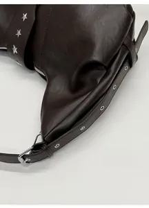 Detailed macro view of dark coffee vintage leather with silver star studs and eyelets