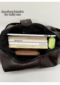 Spacious interior of dark brown tote bag showing laptop and books storage capacity