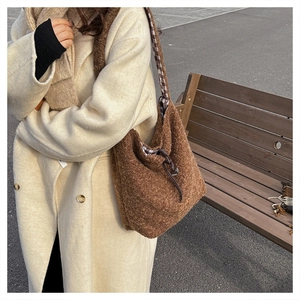 Close-up of brown plush faux fur tote bag showing fuzzy texture and plaid strap details