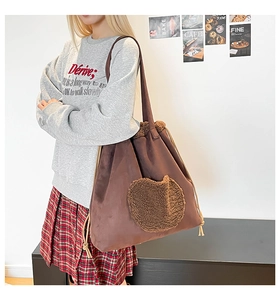 Dettaglio della borsa tote in pelle scamosciata marrone con tasca a cuore e coulisse