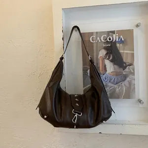 Detail of vintage brown leather tote bag with silver star studs and metal snap hook