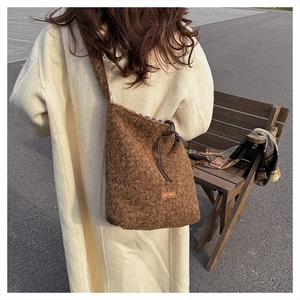 Close-up of brown plush crossbody bag showing soft faux fur texture and drawstring closure