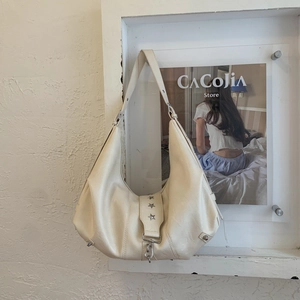 Detail of soft cream faux leather hobo bag with silver star rivets and soft texture