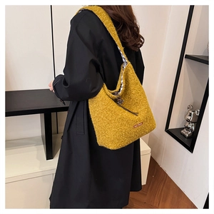 Detail view of yellow plush tote bag with drawstring closure and plaid lining texture