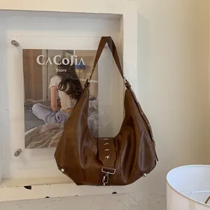 Detail of dark brown vintage hobo bag with star-shaped rivets and leather texture