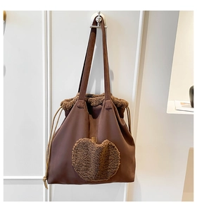 Dettaglio della borsa tote in pelle scamosciata con ricamo mela e bordo in peluche