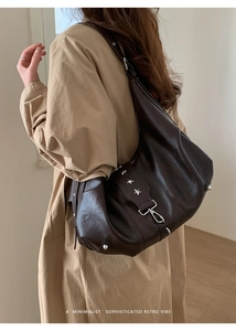 Detail of soft matte leather hobo bag with silver star rivets and metal buckle strap