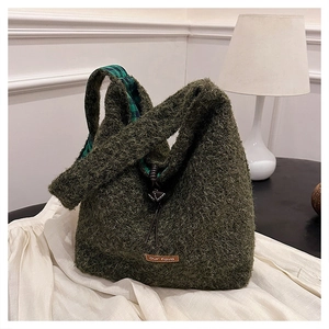 Detail of green fuzzy plush tote bag showing curly faux fur texture and checkered lining