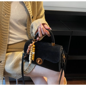 Vintage black leather handbag with suede texture contrast and colorful beaded charm