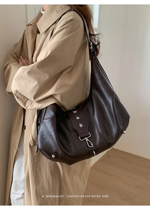 Close-up of vintage dark brown leather hobo bag with silver star rivets and metallic hardware