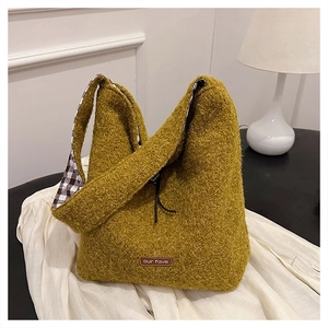 Detail view of mustard yellow plush handbag showing checkered lining and leather label