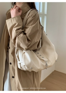 Detail of off-white tote bag with silver star rivets and metal hook hardware detail