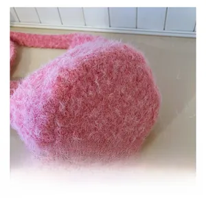 Close-up of pink plush bucket bag showing high-quality stitching and faux fur texture