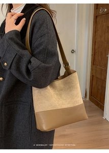Detail of minimalist bucket bag showing beige suede and brown leather patchwork texture
