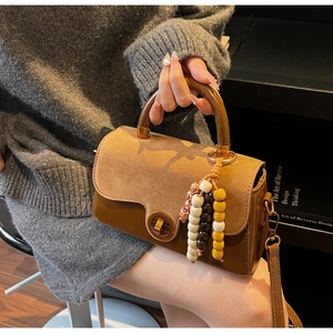 Detail of vintage tote with wooden handle and colorful beaded tassel charm