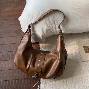 Detail of vintage brown tote bag featuring star rivets and metallic protective feet