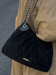 Quilted black suede bucket bag with silver chain strap and metal logo for casual style