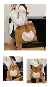 Détail d'un sac seau en daim marron avec un grand cœur en peluche blanc et cordon