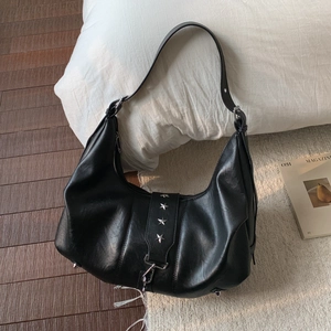 Detail view of black crescent shoulder bag with silver star studs and metal feet