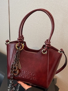 Sac seau trapèze vintage bordeaux avec logo embossé et bandoulière amovible polyvalente