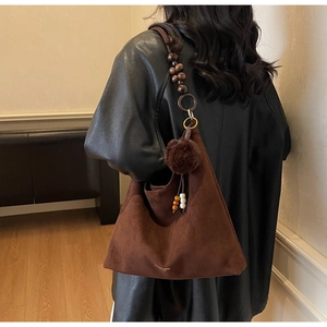 Détail du sac cabas en daim marron foncé avec bandoulière décorative en perles de bois
