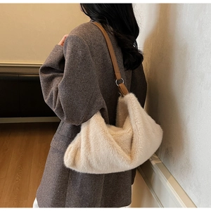 Gros plan détaillé d'un sac à bandoulière en fausse fourrure avec lanière en cuir souple