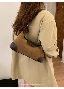Borsa a spalla retrò in pelle scamosciata marrone, indossata con un classico trench beige
