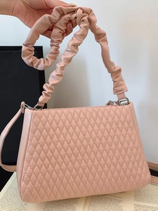 Pink quilted bucket bag with a ruched cloud shoulder strap and minimalist leather design