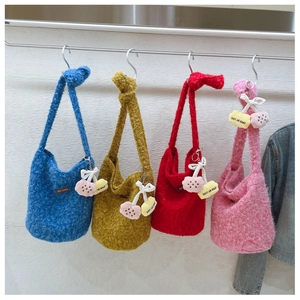 Detail of colorful plush knit bucket bags with cherry charms and bow accents