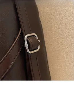 Close-up of the dark brown leather strap with a polished silver square metal buckle