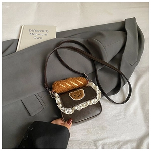 Detail of vintage brown mini crossbody bag featuring lace trim and bear embroidery