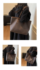 Detail view of large brown tote bag with letter pattern and leather straps