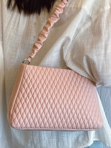 Pink quilted shoulder bag with scrunchie strap and silver metal buckle detail