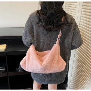 Détail du sac à bandoulière en fausse fourrure rose avec texture douce et boucle en métal