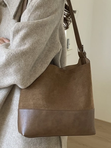Brown retro suede bucket bag with contrast stitching and adjustable shoulder strap
