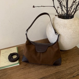 Dettaglio della borsa in pelle scamosciata marrone con finiture in pelle su legno