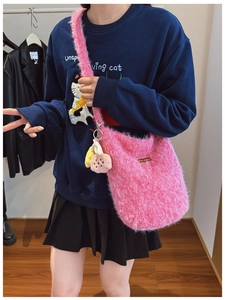 Detail of pink plush bucket bag featuring soft fuzzy texture and cute flower pendant
