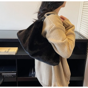 Gros plan du sac hobo en fausse fourrure noire avec anneau métallique sur la bandoulière