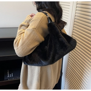 Vue détaillée du sac bandoulière en peluche noire avec lanière en cuir et anneaux argentés