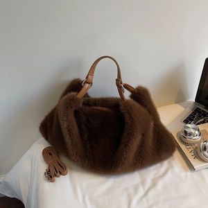 Détail d'un sac à main en peluche marron foncé avec fausse fourrure et anses en cuir