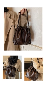 Detail of the brown leather drawstring closure and metallic buckle on bucket bag
