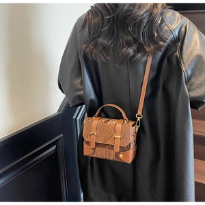 Sac messager vintage marron avec texture froissée, porté par un mannequin en cuir