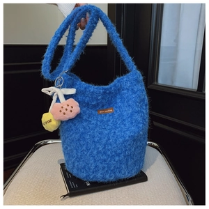 Detail of blue plush bucket bag with fuzzy sheepskin texture and brown leather label