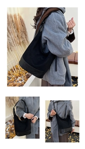Detail view of black faux suede and leather hobo bag showing texture and wide strap