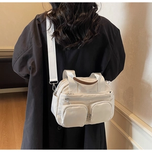 Rear view of a model wearing a large beige corduroy crossbody bag with front pockets