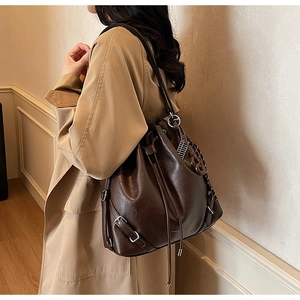 Close-up of the vintage coffee leather bucket bag with silver buckle and drawstring detail