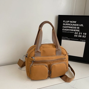 Detail of ginger yellow nylon crossbody bag featuring multi-pocket design and wide strap